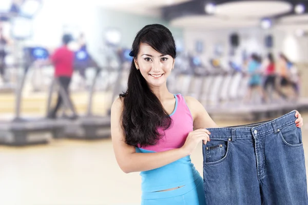 Азиатка сбрасывает вес, позируя в спортзале — стоковое фото