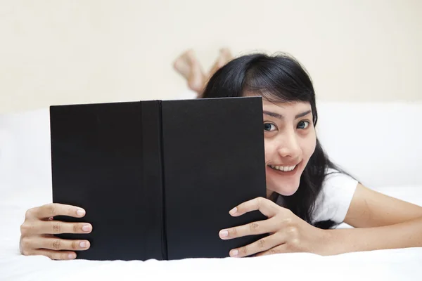 Молодая азиатка читает в спальне — стоковое фото