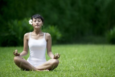 Beautiful Woman meditating in the garden clipart