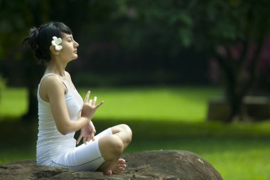 Beautiful Asian Woman Meditating outdoor clipart