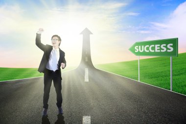 Happy business person standing on the road to success clipart