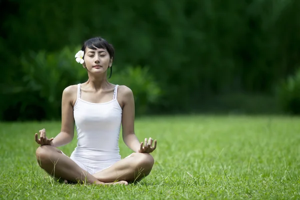 Mooie vrouw mediteren in de tuin — Stockfoto