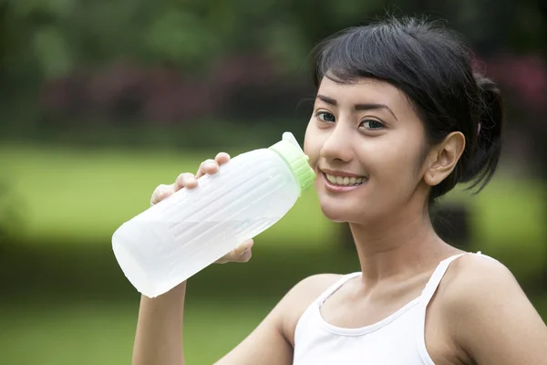 Ładna kobieta z butelką wody mineralnej — Zdjęcie stockowe