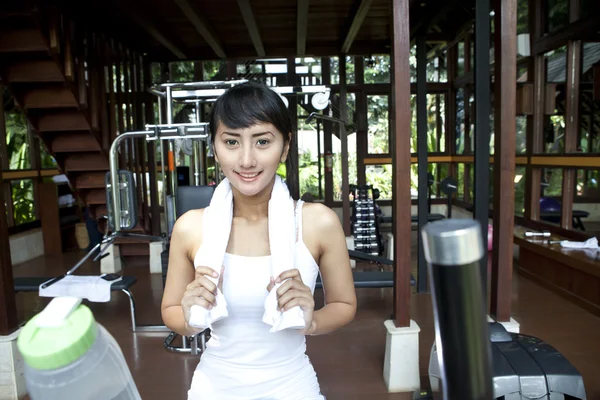 Belle femme asiatique avec serviette posant dans la salle de gym — Photo