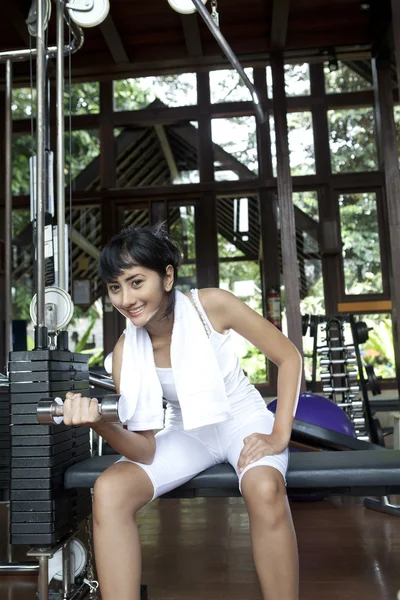 Aziatische vrouw lifhting gewichten in gym — Stockfoto