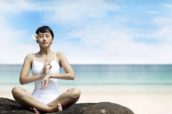 Vacker asiatisk kvinna mediterar på stranden — Stockfoto