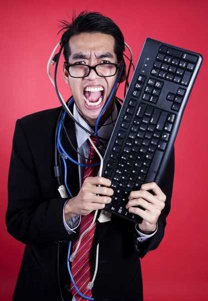 Uomo d'affari pazzo con tastiera e cavi — Foto Stock
