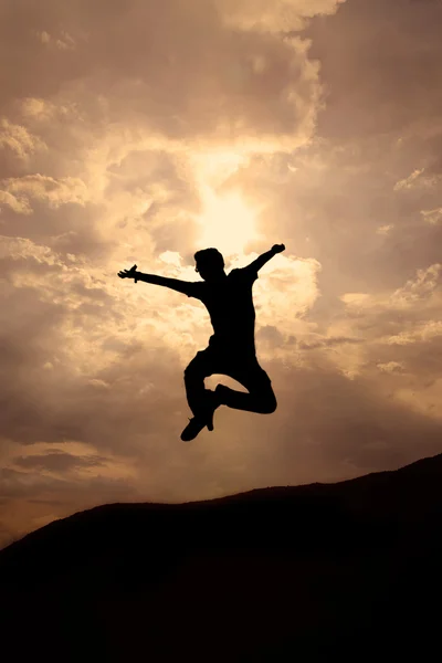 Silhuette de homem jovem saltando — Fotografia de Stock