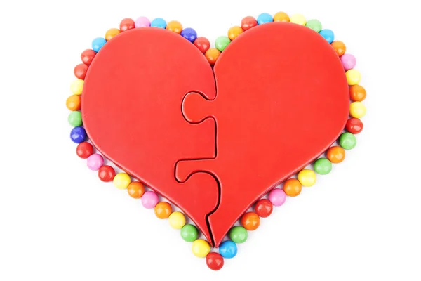 Puzzle de coeur isolé avec des bonbons autour — Photo