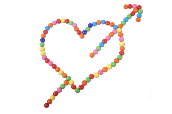 Corazón hecho de caramelos de colores con flecha —  Fotos de Stock