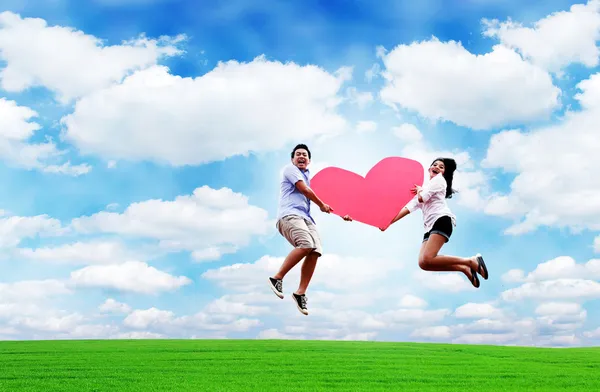 Verliebte springen mit Herz in den Himmel — Stockfoto