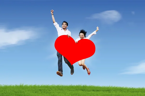 Joyeux couple sautant contre le ciel bleu — Photo
