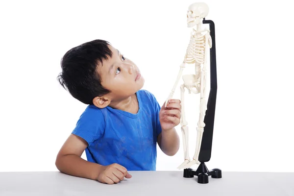 Aziatisch jongen met menselijk skelet — Stockfoto