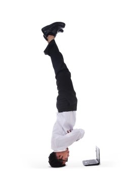 Isolated businessman headstand with laptop clipart