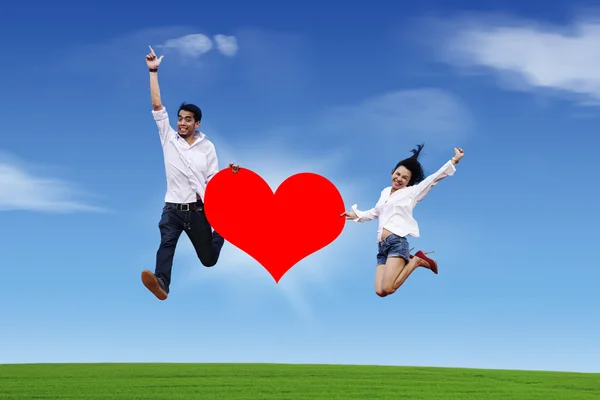 Couple volant avec coeur sur ciel bleu — Photo