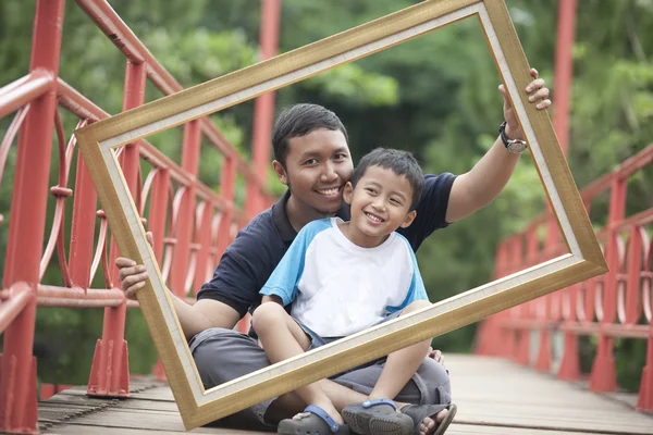 Pai e filho com uma moldura — Fotografia de Stock