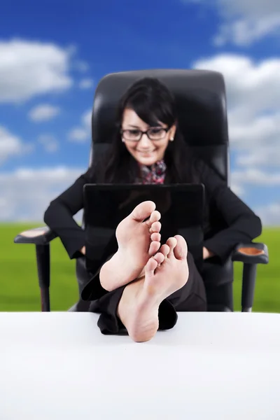 Femme d'affaires avec les pieds sur une table — Photo