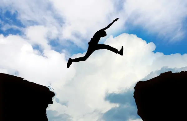 Silueta del hombre saltando acantilado — Foto de Stock