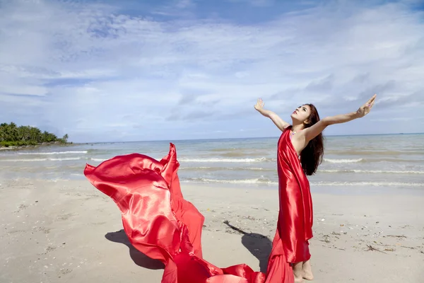 Kvinna i röd halsduk på stranden — Stockfoto