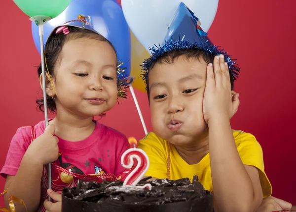 Дети задувают свечи на день рождения — стоковое фото