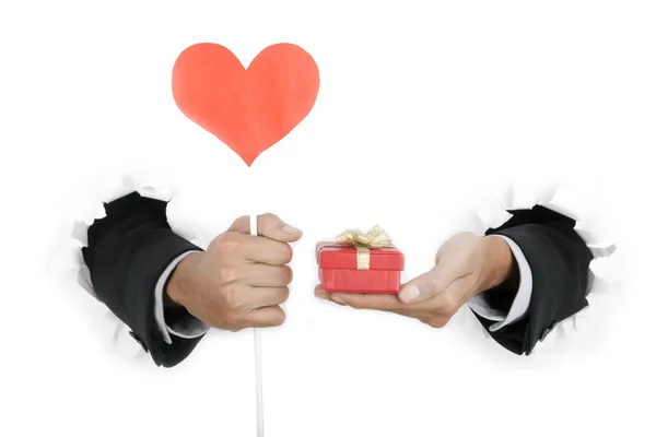 Рука бизнесмена держит в руках подарок и форму сердца — стоковое фото