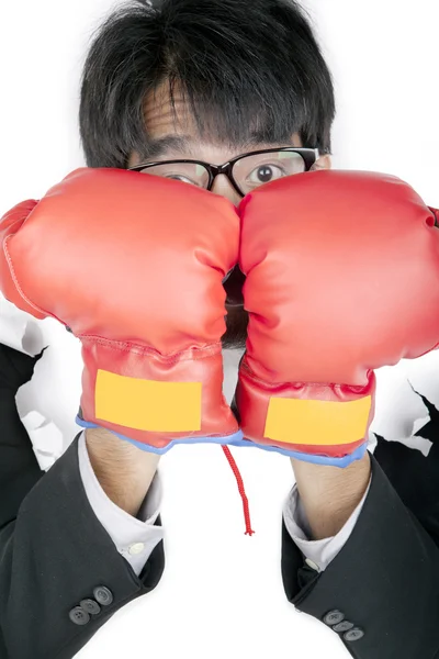 Испуганный бизнесмен защищает свое лицо боксерскими перчатками — стоковое фото