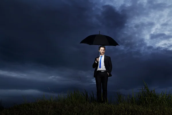 Zakenman permanent met paraplu — Stockfoto
