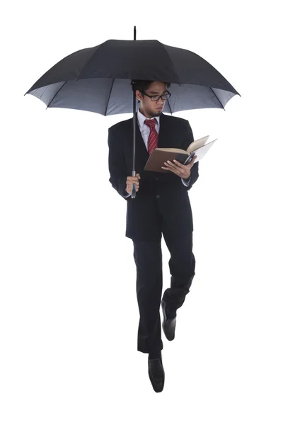 读一本书在伞下的商人 — 图库照片