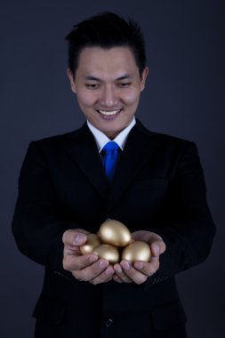 Happy businessman with golden eggs clipart