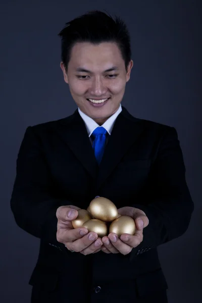Happy businessman with golden eggs — Stock Photo, Image