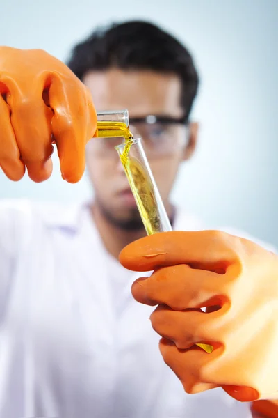 Scienziato versando il prodotto chimico liquido — Foto Stock