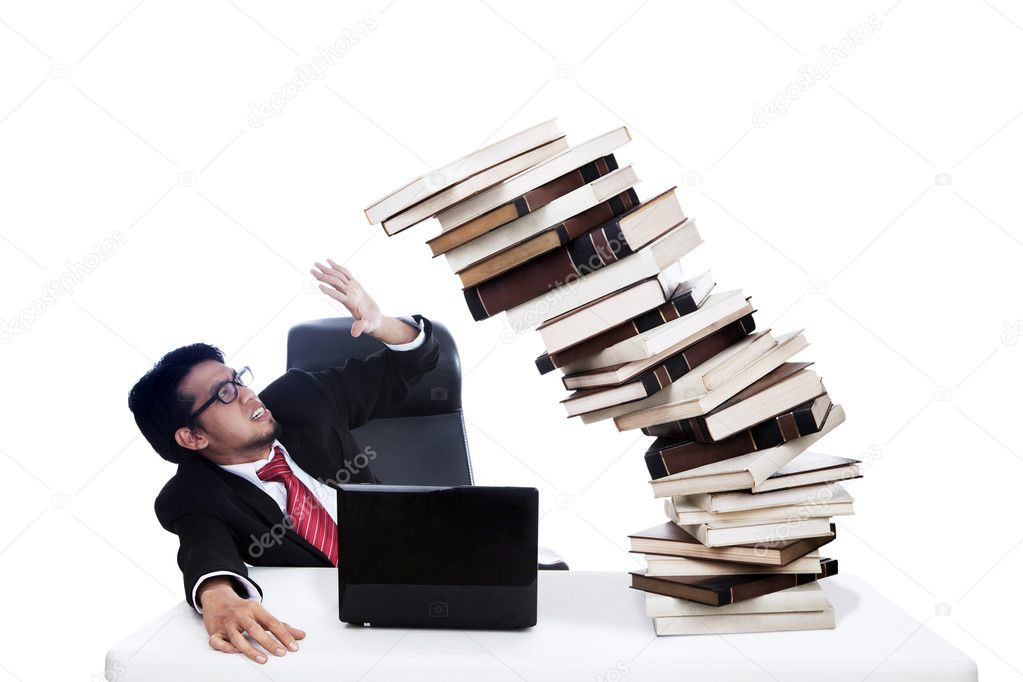 Scared businessman with pile of books