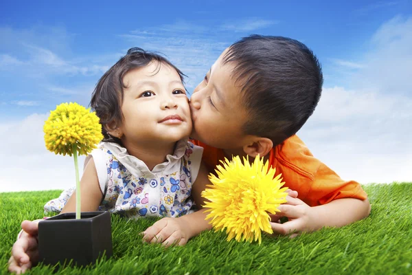 Junge küsst seine Schwester im Frühling — Stockfoto