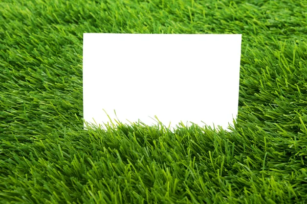 Papier blanc tourné sur l'herbe verte — Photo