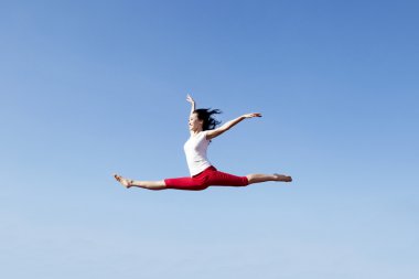 Asyalı kadın üzerinde mavi gökyüzü atlama