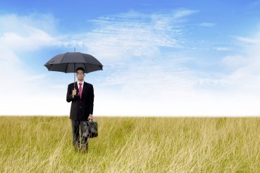 Businessman with umbrella shot outdoor clipart