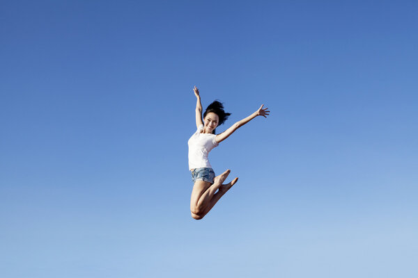 Joyful asian woman jumping