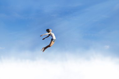 Freedom: Woman jumping over the clouds clipart