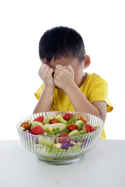 Плачущий мальчик с луком фруктового салата — стоковое фото