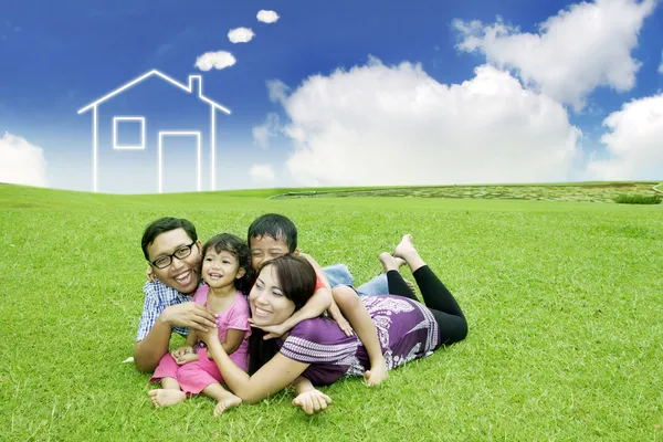 年轻的亚洲家庭与梦想中的房子在字段上 — 图库照片
