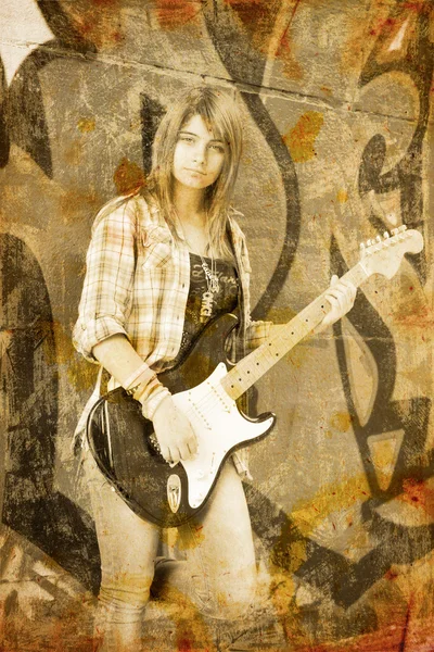 Closeup portrait of a young girl with guitar against graffiti ba — Stock Photo, Image