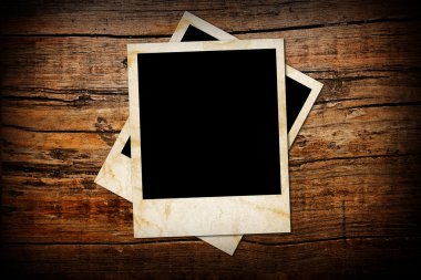 Aged photo frames on wood background clipart