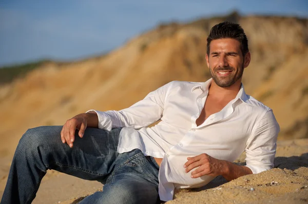 Relalaxed man seated on the sand — Stock Photo, Image