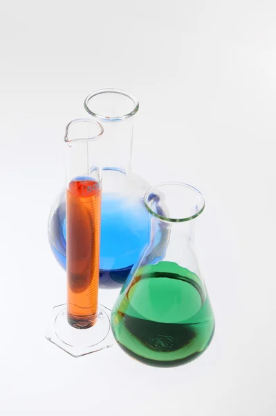 Vidros de laboratório sortidos com líquido multicolorido — Fotografia de Stock