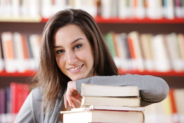 Χαμογελώντας σπουδαστής κολεγίου με μια στοίβα από βιβλία — Φωτογραφία Αρχείου