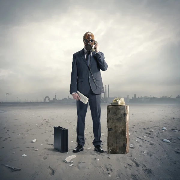 Businessman with gasmask at phone — Stock Photo, Image