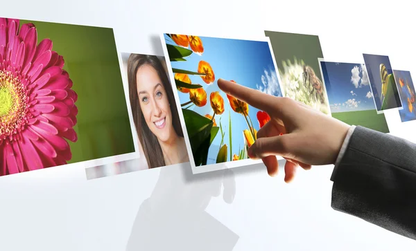 Touchscreen interface: man hand reaching images on the screen — Stock Photo, Image