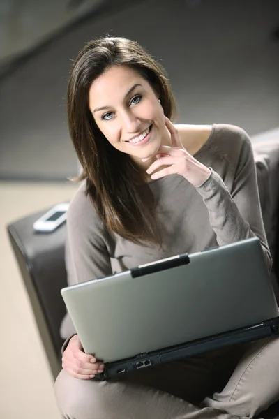 Jovem mulher no sofá com laptop — Fotografia de Stock