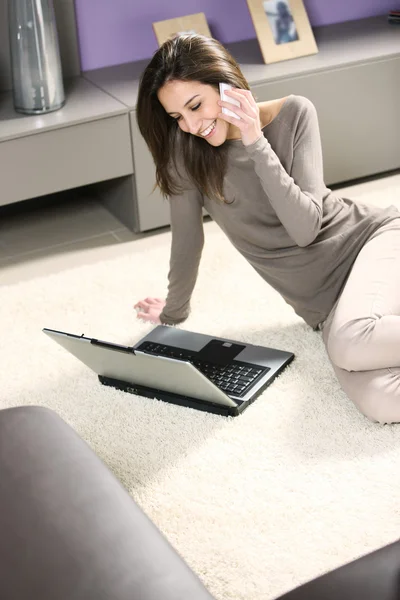 Smiling woman with mobile phone and laptop — Stock Photo, Image