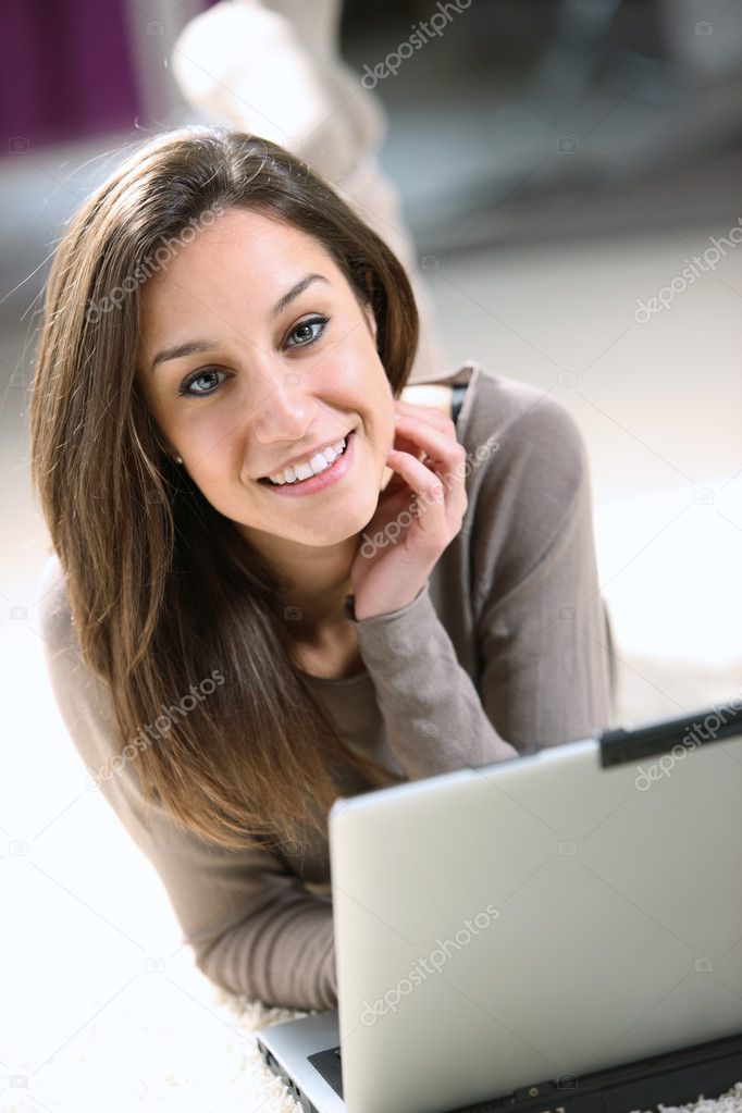 Smiling woman using her laptop in the living room.